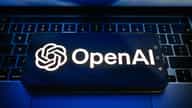OpenAI branding displayed on a screen, after the company fired three staff for mishandling sensitive information