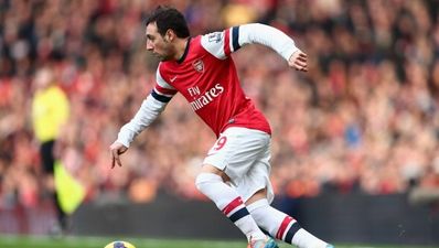 Pic: Santi Cazorla and Robert Pires pose with a sign that Spurs fans won’t like at all